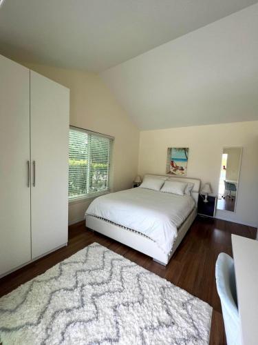 a bedroom with a white bed and a rug at SWISS 24 - Lake Stephanie in Clermont