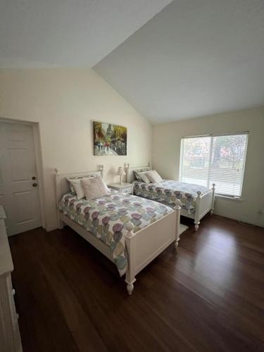 a bedroom with two beds and a window at SWISS 24 - Lake Stephanie in Clermont