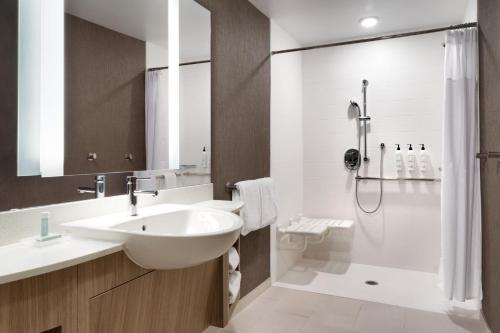 a white bathroom with a sink and a shower at SpringHill Suites by Marriott Phoenix Scottsdale in Scottsdale