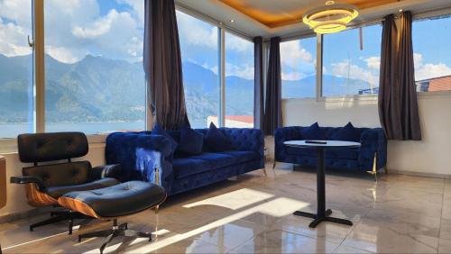sala de estar con muebles azules y ventanas grandes. en luxury atitlan suites en San Pedro La Laguna