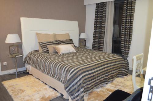 a bedroom with a large bed with a striped blanket at Casa de Campo de SOUTELO in Soutelo
