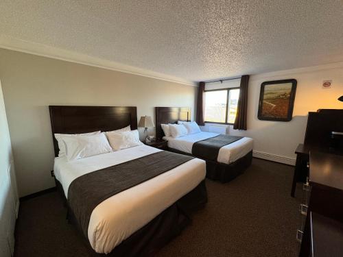 a hotel room with two beds and a window at River Inn in Nipawin