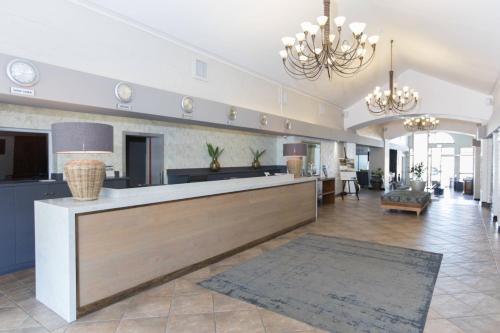 a large kitchen and living room with a reception counter at Protea Hotel by Marriott Stellenbosch & Conference Centre in Stellenbosch