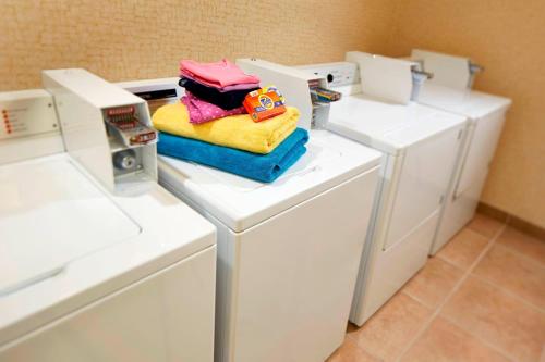 uma lavandaria com máquinas de lavar roupa brancas e toalhas em Courtyard Vallejo Napa Valley em Vallejo