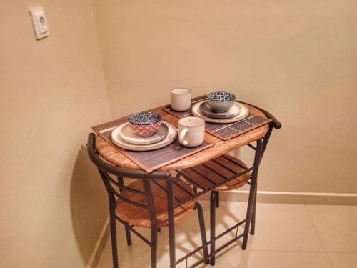 a small wooden table with plates and cups on it at Skiff_View in Kastoria