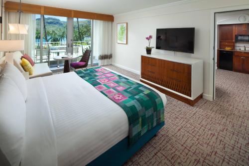 a hotel room with a large bed and a flat screen tv at Marriott's Kaua'i Beach Club in Lihue