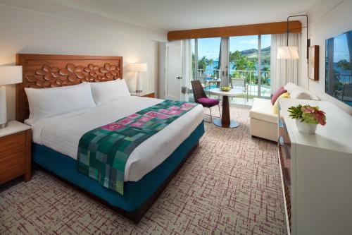 リフエにあるマリオッツ カウアイ ビーチ クラブの大きなベッドとバルコニーが備わるホテルルームです。