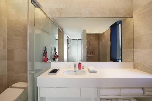 a bathroom with a white sink and a mirror at Moxy Seoul Insadong in Seoul