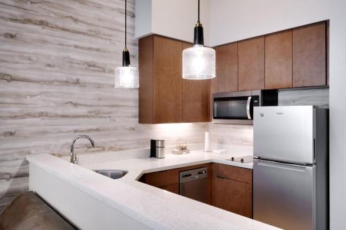 a kitchen with wooden cabinets and a white refrigerator at Residence Inn by Marriott Vail in Vail