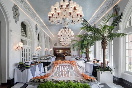 a grand ballroom with white tables and chandeliers at Grand Galvez Resort, Autograph Collection in Galveston