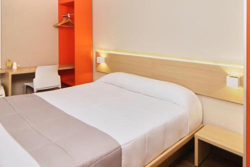 a bedroom with a bed and a desk and a chair at City Express Junior by Marriott Tijuana Otay in Tijuana