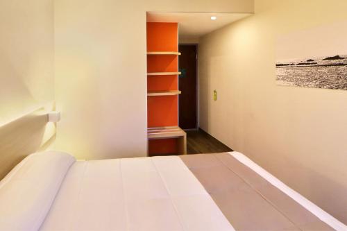 a bedroom with a bed and a painting on the wall at City Express Junior by Marriott Tijuana Otay in Tijuana