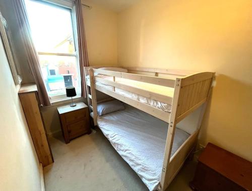 Two bed flat in popular York Rd في برمنغهام: غرفة نوم بسريرين بطابقين ونافذة