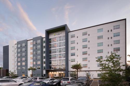 a large white building with cars parked in a parking lot at Element by Westin Orlando International Drive in Orlando