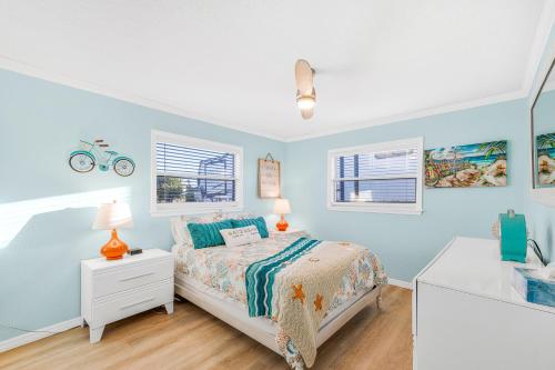 een slaapkamer met blauwe muren en een bed met een nachtkastje bij Hot tub and Dock Gilligan's on the Island in Matlacha