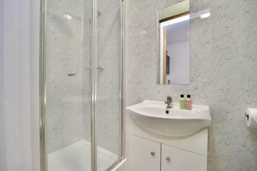 a white bathroom with a sink and a shower at Matlock Studio 2 – Coventry in Coventry