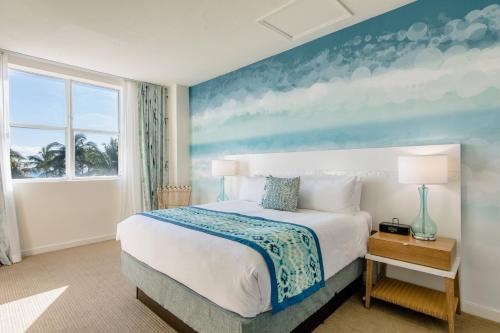 a bedroom with a large bed with a painting on the wall at Marriott Vacation Club®, South Beach    in Miami Beach