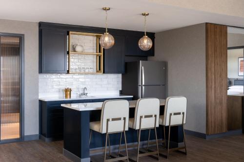 a kitchen with navy blue cabinets and white appliances at Delta Hotels by Marriott Wichita Falls Convention Center in Wichita Falls
