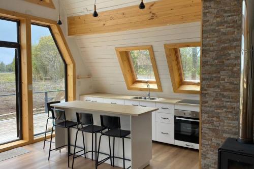 a kitchen with a counter with stools and a stove at Casa tipo A en laguna de trapen in Puerto Montt