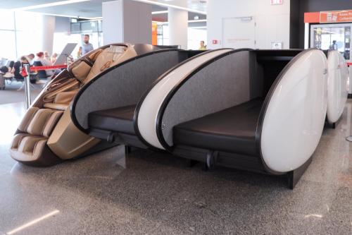 una fila di sedili vuoti in un aeroporto di Sleeping Pods GoSleep - Inside of Warsaw Chopin Airport, non schengen restricted zone after passport control, near Gate 2N a Varsavia