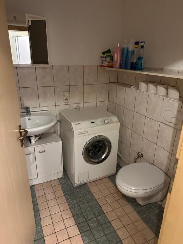 ein Badezimmer mit einer Waschmaschine, einem WC und einem Waschbecken in der Unterkunft 2 Zimmer Wohnung Bruchsal (Monteurzimmer) in Bruchsal