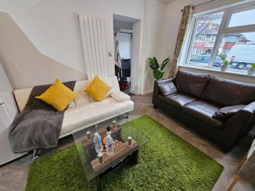 a living room with a couch and a table at Stunning self-contained flat in house in Raynes Park