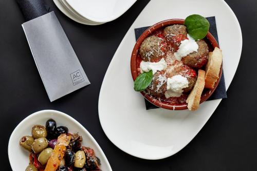 a white plate with a bowl of food on a table at AC Hotel Miami Wynwood in Miami