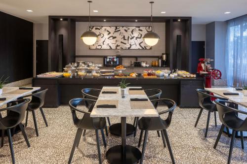 a restaurant with tables and chairs in front of a kitchen at AC Hotel Miami Wynwood in Miami