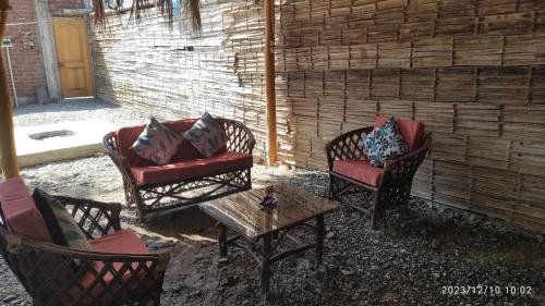 eine Terrasse mit 2 Stühlen und einem Couchtisch in der Unterkunft La casa de Joan in Máncora