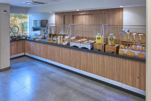 a restaurant with a counter with food and drinks at City Express by Marriott Saltillo Norte in Saltillo