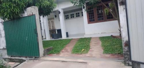 a green door in front of a house at Araliya Uyana Residencies Colombo - Entire House with Two Bedrooms in Colombo