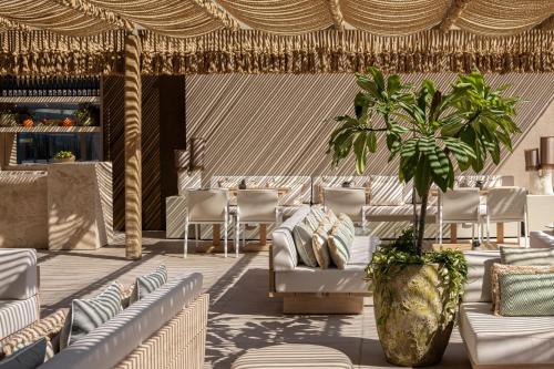 a lobby with white chairs and a palm tree at Sheraton Grand Tel Aviv in Tel Aviv
