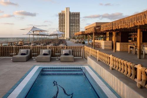 a swimming pool on the roof of a building at Sheraton Grand Tel Aviv in Tel Aviv