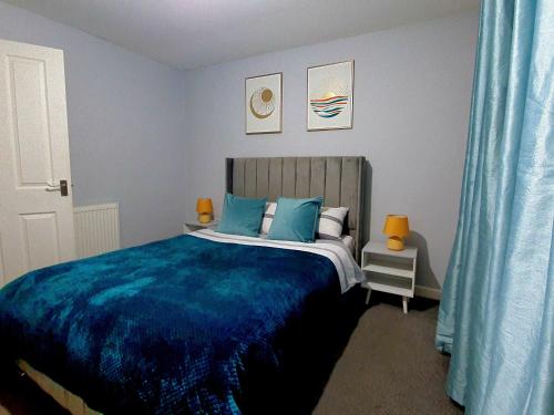 a bedroom with a bed with a blue blanket at Serviced Accommodation near London and Stansted - 2 bedrooms  in Harlow