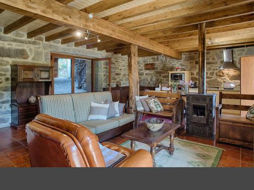 a living room with a couch and a fireplace at Casa Alagoa in Castro Laboreiro
