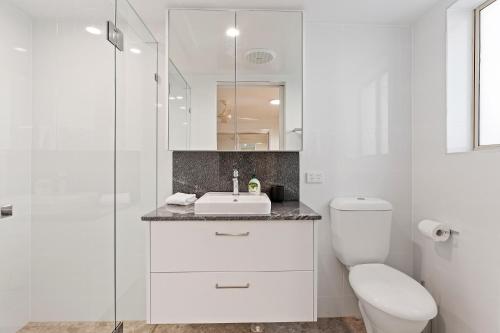 バイロンベイにあるWaterview Beachside Apartment - Palms 2の洗面台とトイレを備えた白いバスルーム