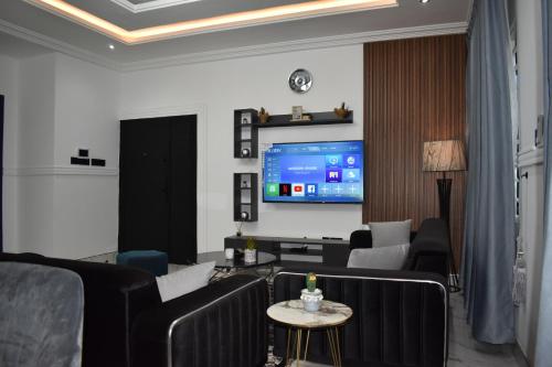 a living room with a couch and a tv at Masayi Residences in Adentan