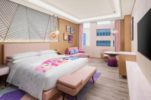 a bedroom with a large bed and a living room at Shanghai Marriott Hotel Pudong South in Nanhui