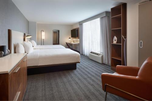 a hotel room with a bed and a chair at Courtyard by Marriott Kitchener in Kitchener