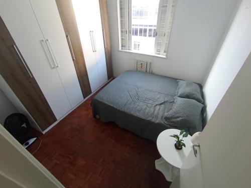 um pequeno quarto com uma cama e uma mesa em Leme no Rio de Janeiro