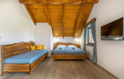 2 letti in una camera da letto con soffitto in legno di Villa D-IKA a Brušane