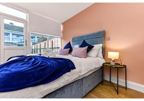 um quarto com uma cama grande e uma janela em Stunning Family Home - Sleeps 11 em Londres