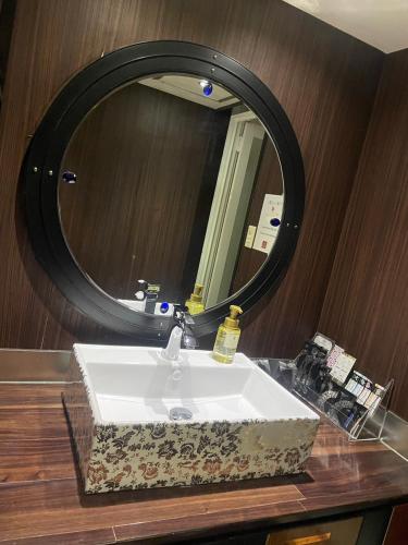 a bathroom sink with a large mirror above it at ホテルチャハヤ in Itako