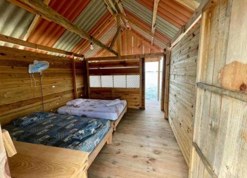 a room with two beds in a wooden cabin at Cabañas sobre el mar en Guna Yala in Playón Chico