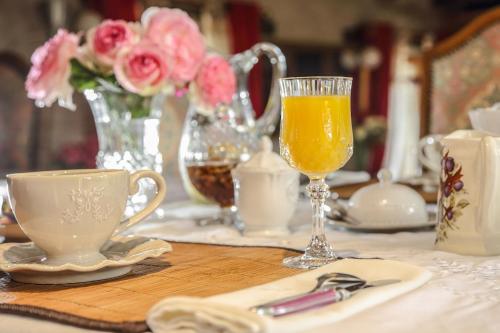 einen Tisch mit einer Tasse und einem Glas Orangensaft in der Unterkunft BUNGALOW in Saint-André-dʼAllas