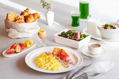 a table with plates of breakfast foods and drinks at Courtyard by Marriott Seoul Pangyo in Seongnam