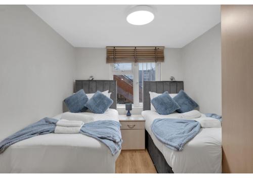 sypialnia z 2 łóżkami i niebieskimi poduszkami w obiekcie Relaxing 1BR Flat - Cozy and comfortable w Londynie