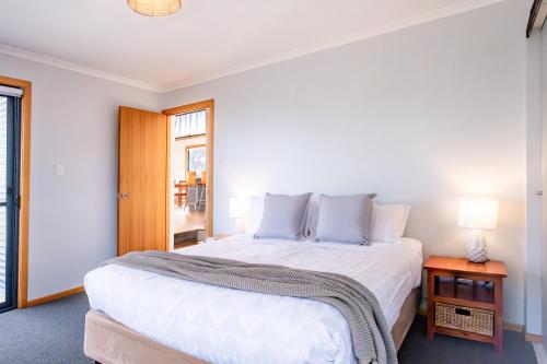 a bedroom with a large white bed and a window at Beachcomber in Coles Bay