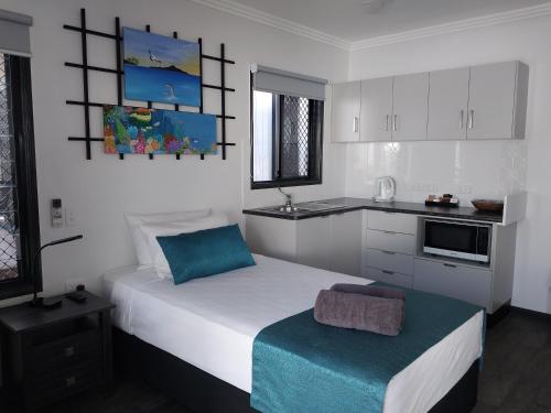 a bedroom with a large bed and a kitchen at The Dugongs' Rest in Horn