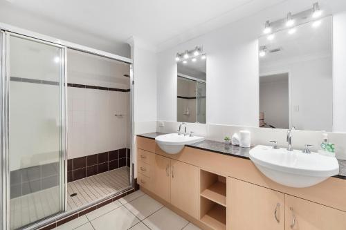 uma casa de banho com 2 lavatórios e um chuveiro em Spacious 3 Bedroom Townhouse in Cairns City em Cairns
